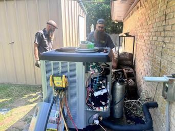 Webb's Electric, Heating & Air HVAC technician installing a new air conditioner in Sherman at a grey house.